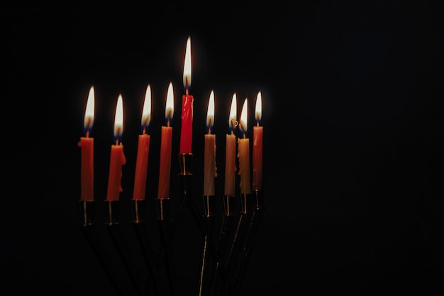 Kaars lite op de traditionele zilveren menorah zwarte achtergrond van de Chanoeka