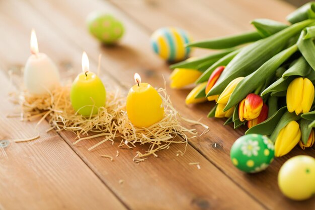 Foto kaarsen in de vorm van paaseieren en tulpenbloemen