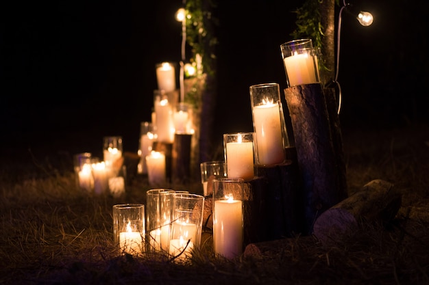 Kaarsen in glazen flessen in de decoratie van de nachtceremonie