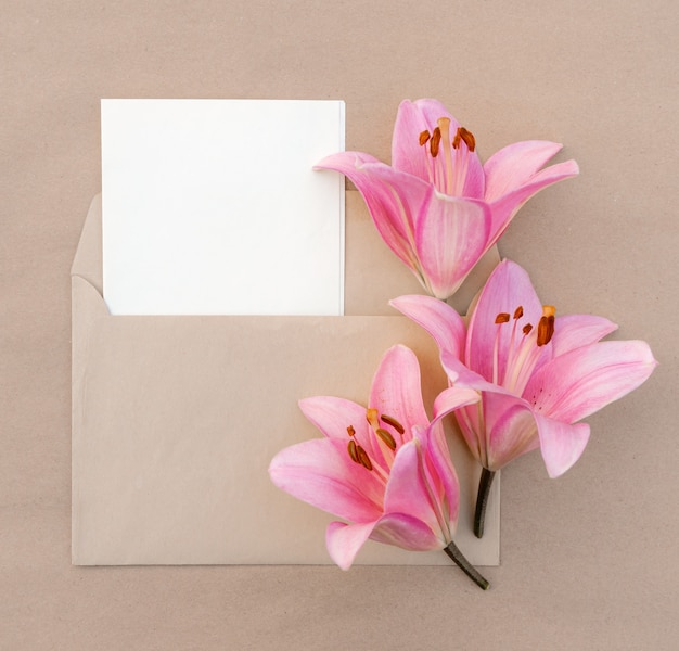 Kaart met een boeket roze lelies in een envelop met kopieerruimte voor ontwerp