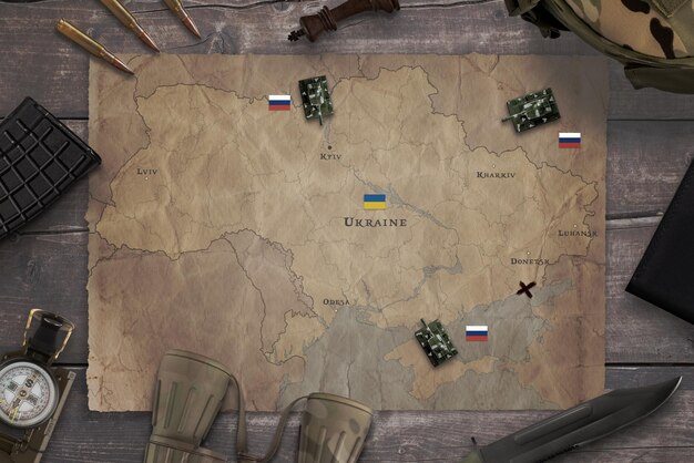 Kaart van de Russische invasie van Oekraïne met militaire uitrusting op de tafel Top view flat lay concept compositie
