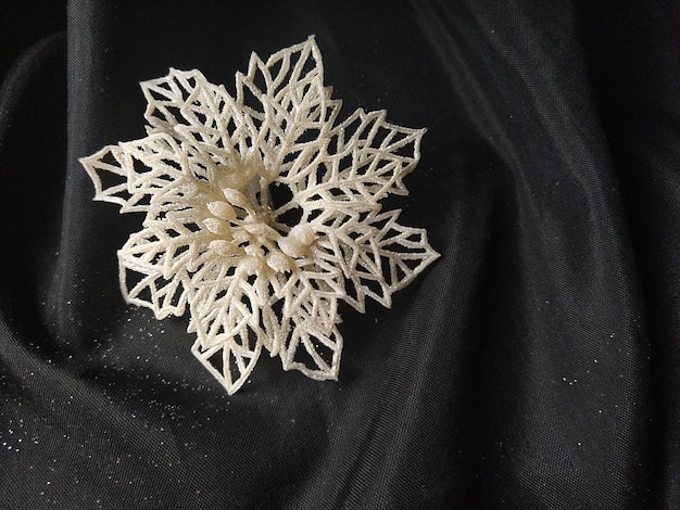 Kaart voor het nieuwe jaar en Kerstmis met versieringen Kerstversiering en schittert op een zwarte achtergrond Bruin glanzend gestreepte ballen bloemen en witte sneeuwvlokken gouden twijgen met bessen