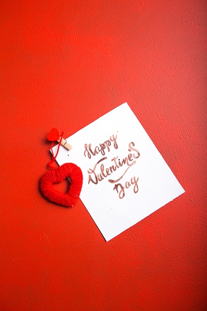 Kaartbericht met Happy Valentijnsdag en hart speelgoed op rode tafel