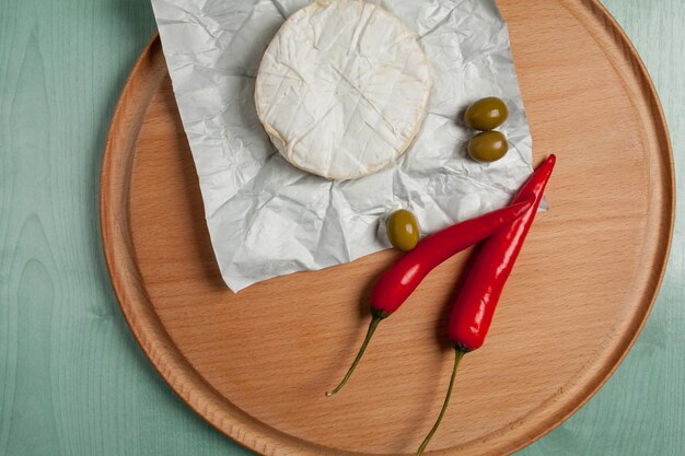 kaas brie camembert olijven chili op een houten lichte achtergrond bovenaanzicht Camembert kaas