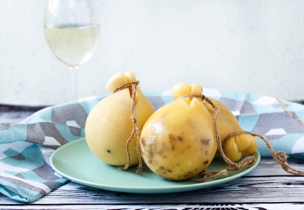 Kaas Caciocavallo op een plaat houten achtergrond met wijn. Kaaspeer