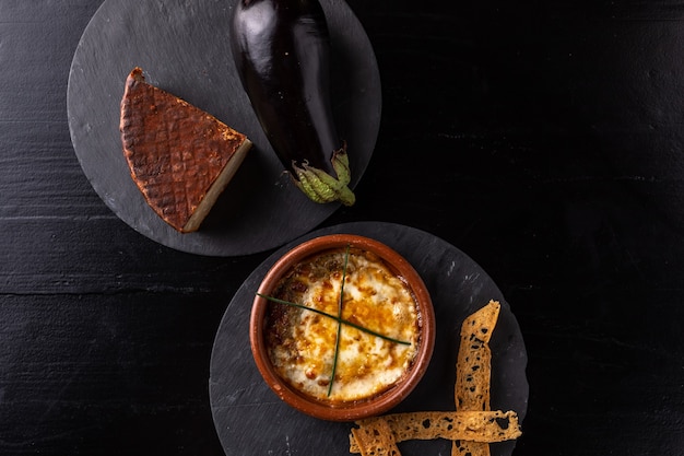 Kaas en aubergine in de oven met zwarte achtergrond - Gastronomie - zwarte achtergrond.