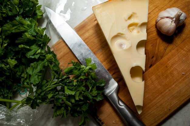 kaas, knoflook en groenten liggen op een houten snijplank