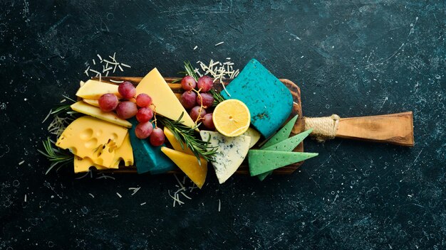 Kaas. Set gekleurde kazen: brie, blauw, gorgonzola, parmezaanse kaas en maasdam op een zwarte stenen achtergrond. Gratis exemplaar ruimte. Bovenaanzicht.