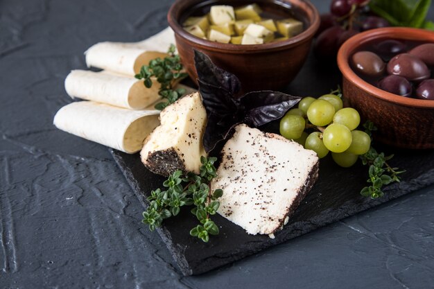 Kaas voorgerecht selectie. Verscheidenheid van kaas, brood, stokbrood, druiven, olijven