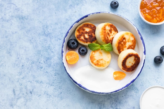 Kaaspannenkoekjes of syrniki met bosbessenphysalis en yoghurt Gezond en lekker ontbijt