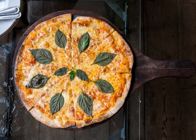 Kaaspizza met top van de de fusie de thaise stijl van het basilicumblad op de houten lijst.