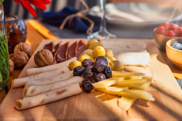 Kaasplankje met druiven op houten tafel, bovenaanzicht. Geassorteerde kaas en olijven op houten achtergrond