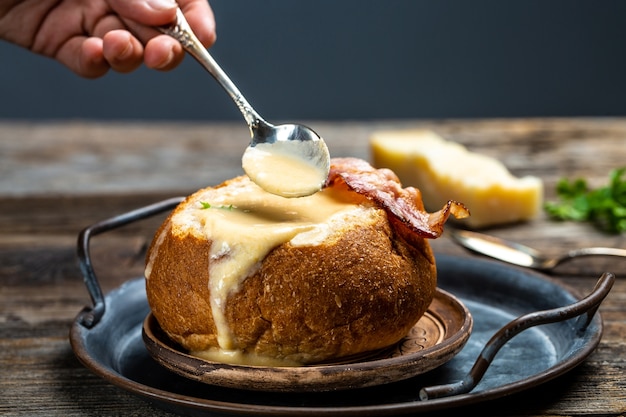 Kaassoep met spek en kruiden geserveerd op brood