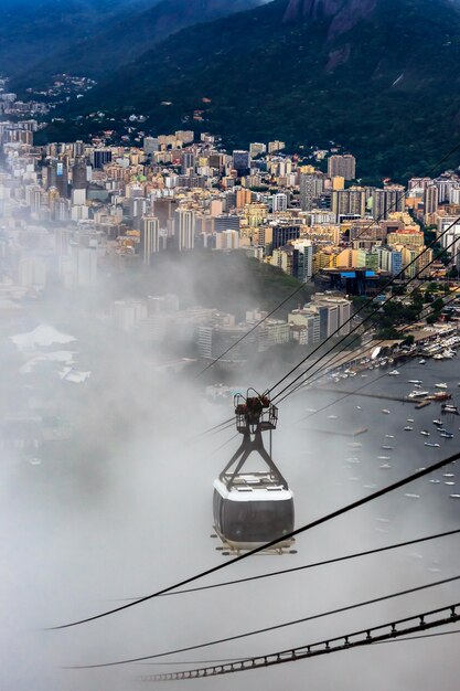 Kabelbaan in wolken op weg naar de top van SugarLoaf en het panorama van de stad van Rio de Janeiro, Brazilië