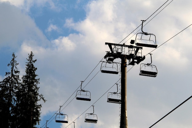 Kabelbaansilhouet met lege stoelen boven bomen