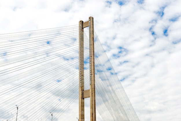 Kabelbrug over rivier met witte wolken