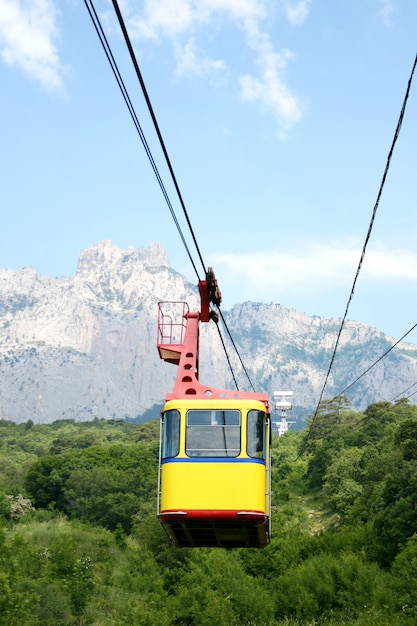 Kabelwagencabine op een bergachtergrond. De opkomst van de kabelbaan naar de bergen in de zomer