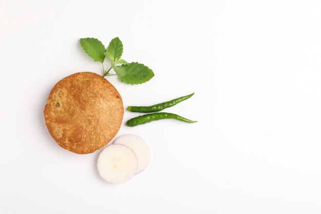 Kachori, green chilly and onion. kachori is a spicy snack from India also spelled as kachauri and kachodi.