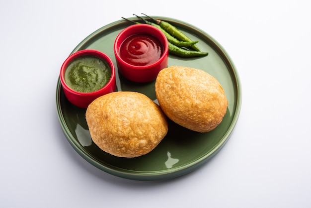 Photo kachori is a flat spicy snack from india also spelled as kachauri and kachodi. served with tomato ketchup. selective focus
