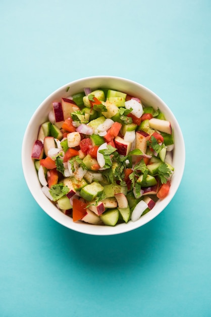 Kachumber OR Indian Green Salad also known as Koshimbir. Served in a bowl over moody background. Selective focus