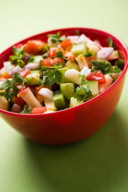 Kachumber OF Indiase Groene Salade ook bekend als Koshimbir. Geserveerd in een kom over humeurige achtergrond. Selectieve focus
