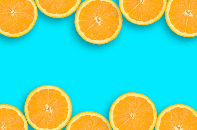 Kader van een oranje citrusvruchtenplakken op heldere blauwe achtergrond