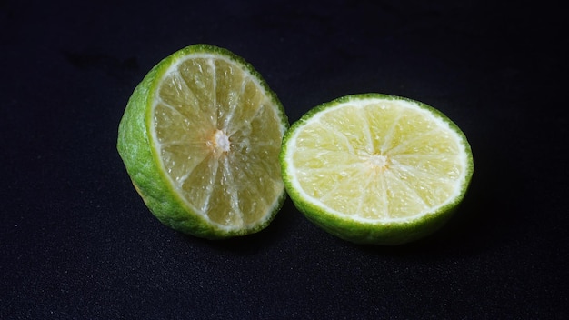 Photo kaffir lime or citrus hystrix that has been sliced focus selected black background