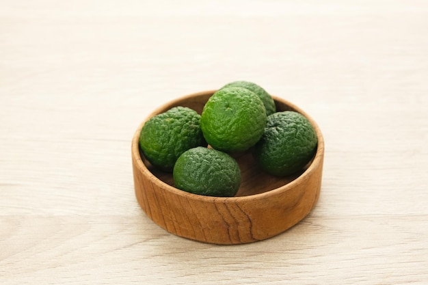 Photo kaffir lime or jeruk limau on wooden table food ingredient