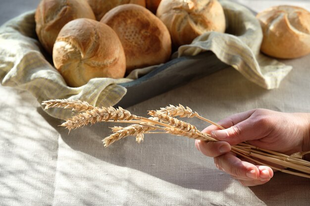 Kaiser or Vienna buns in bread basket with linen towel.