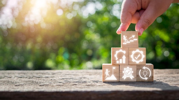 KAIZEN concept Person hand holding wooden block with kaizen icon on virtual screen Business philosophy and corporate strategy concept of continual improvement