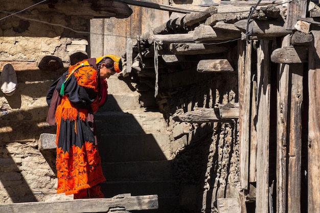 Kalash-vrouw in traditionele kleding aan het werk in de buurt van haar huis in het dorp Kalash, Gilgit, Pakistan