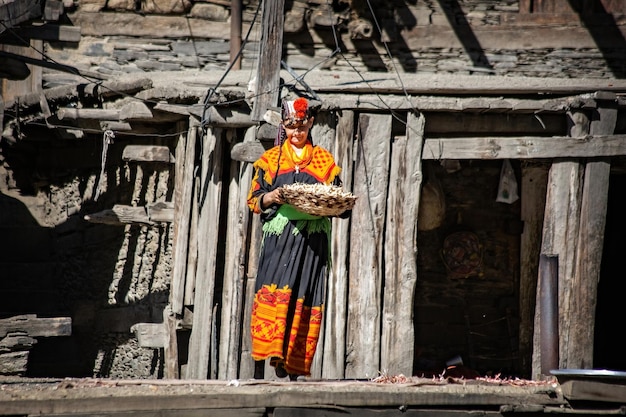 Kalash woman wearing traditional clothes working near her house in Kalash village Gilgit Pakistan