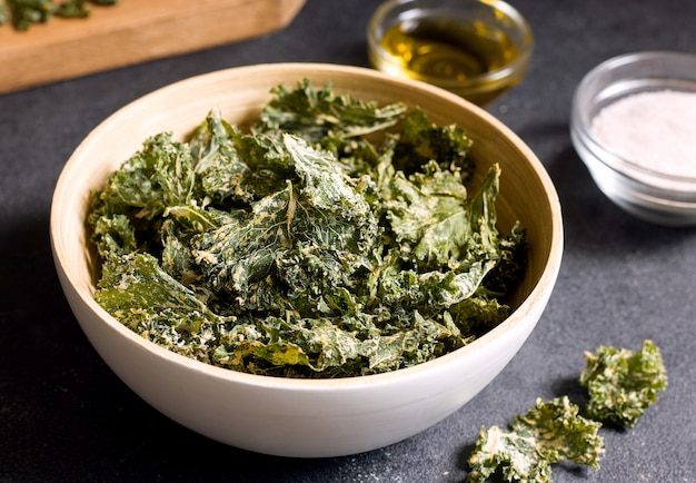 Kale chips in a bowl on a black table