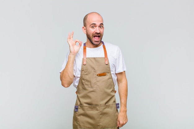 Kale man die zich succesvol en tevreden voelt, glimlachend met wijd open mond, goed teken met hand makend