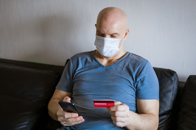 Kale man in beschermend masker met telefoon