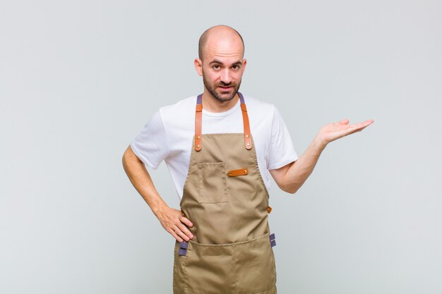 Kale man lacht, voelt zich zelfverzekerd, succesvol en gelukkig, toont concept of idee op kopie ruimte aan de zijkant