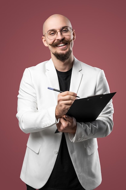 Foto kale man met snor en baard in een pak met klembord en pen geïsoleerde backgroundc