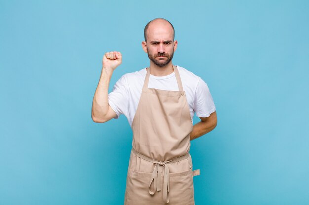 Kale man voelt zich serieus, sterk en rebels, steekt zijn vuist op, protesteert of vecht voor revolutie