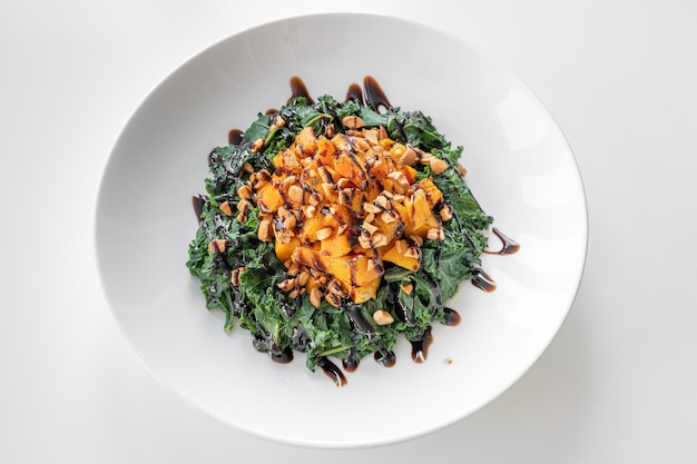 Kale and Squash Salad served in a dish isolated on grey background top view