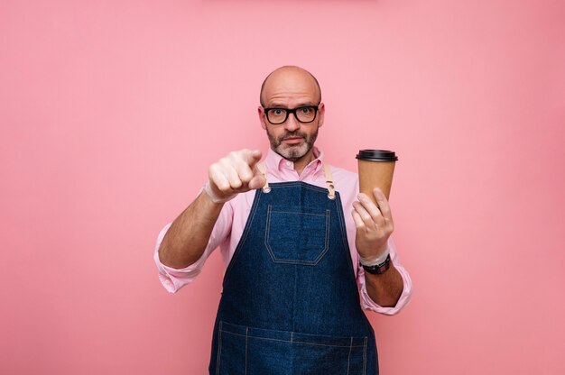 Kale volwassen man wijzende vingers en koffie in recyclebare kartonnen beker