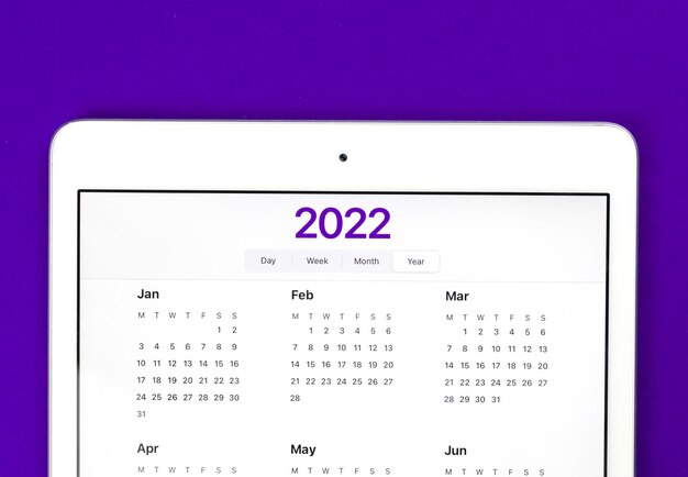 Kalender 2022 op het scherm. Heldere platliggende achtergrond, om doelen te doen en planning voor nieuwjaarsconcept. Bovenaanzicht foto