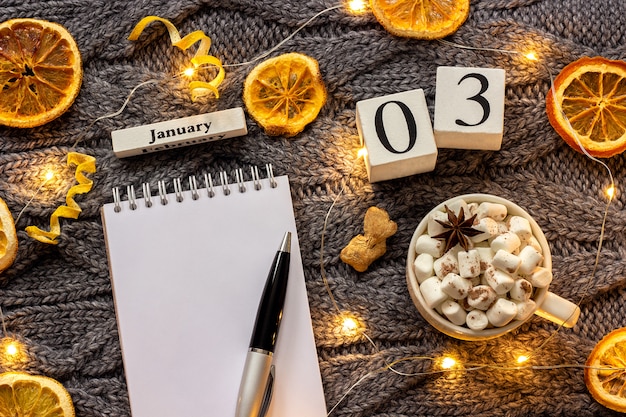 Kalender 3 januari Beker van cacao en lege open blocnote