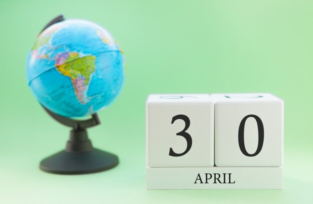 Kalender april 30 april. Een deel van een reeks op vage groene achtergrond en bol.