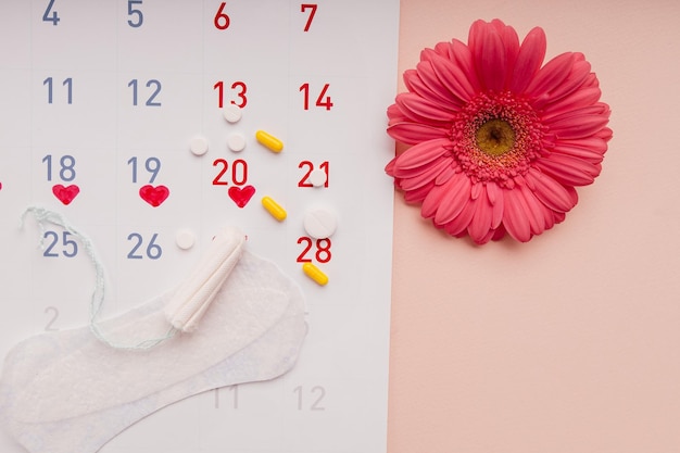 Kalender met en diverse soorten dames maandverband en tampons versierd met roze bloem