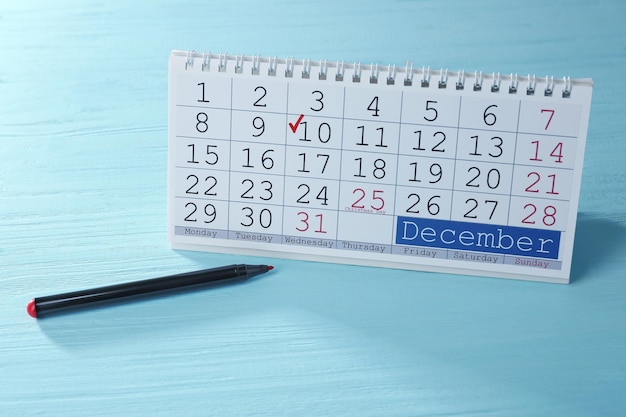 Kalender met gemarkeerde datum en marker op houten achtergrond