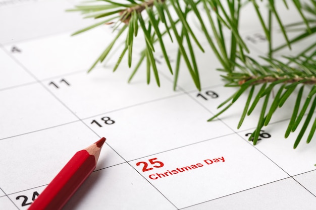Foto kalender met gemarkeerde datum van kerstdag en boomtak