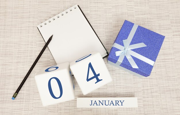 Kalender met trendy blauwe tekst en cijfers voor 4 januari en een geschenk in een doos