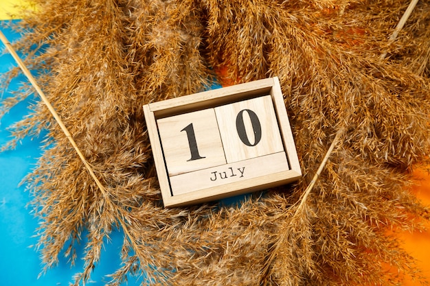 Kalender van houten kubussen met cijfers en maanden. Een nummer kiezen op een houten kalender. 1 juli. Juli datum