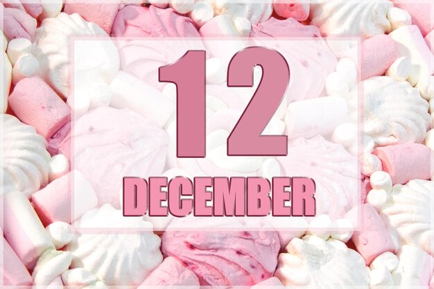 Kalenderdatum op de achtergrond van witte en roze marshmallows 12 december is de twaalfde dag van de maand