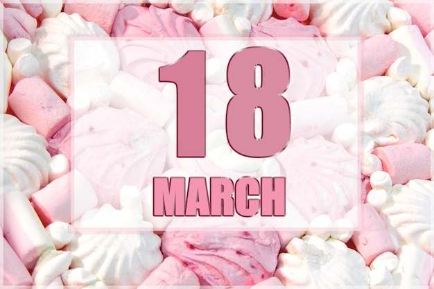 Kalenderdatum op de achtergrond van witte en roze marshmallows 18 maart is de achttiende dag van de maand
